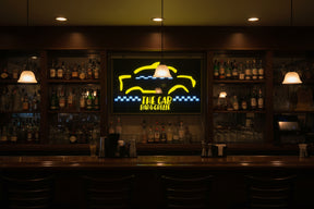 Neon sign for 'The Cab Bar & Grille' with yellow and blue design.
